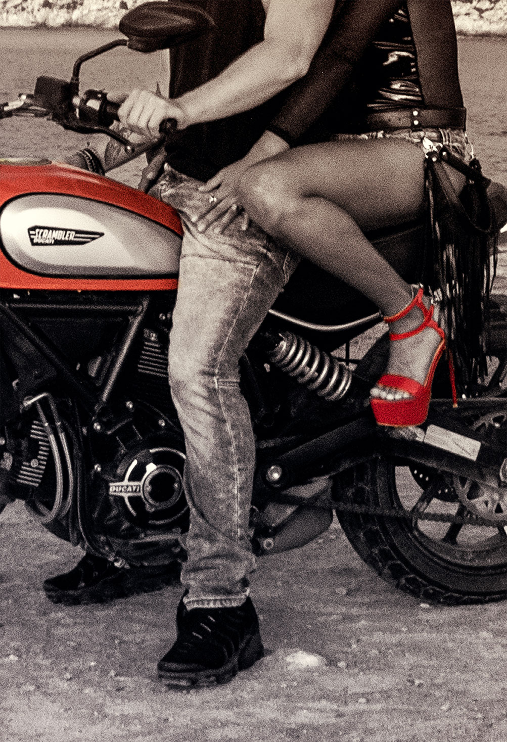 Black and white photography of a couple riding a motorcycle at Es Calo beach, Formentera, Spain, (Nos Dren).